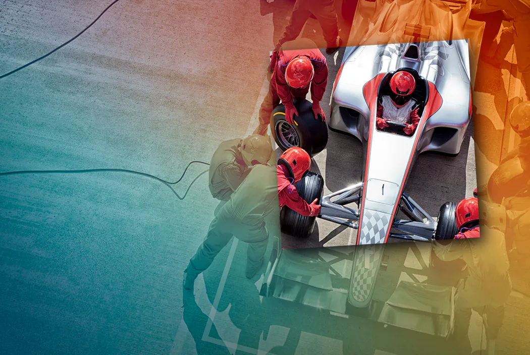 Pit crew servicing a race car, representing coordinated teamwork.