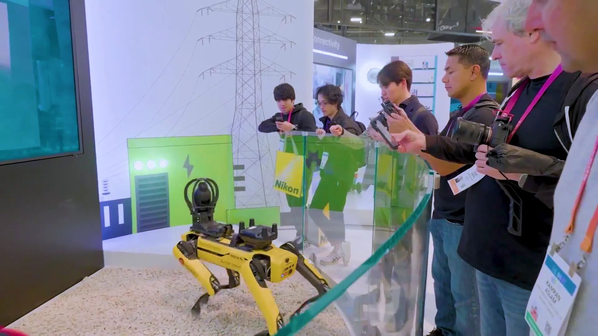 Attendees viewing a robotic dog demonstration inside an interactive technology exhibit.